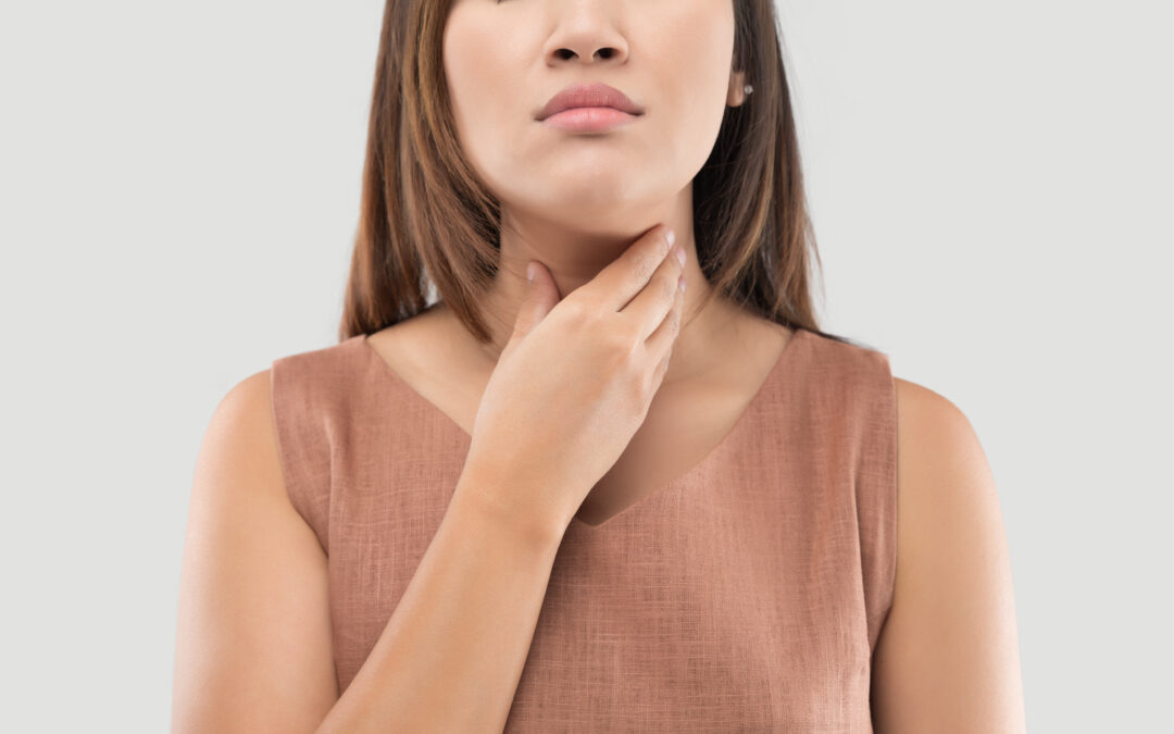 Image of women touching her throat and thyroid area.