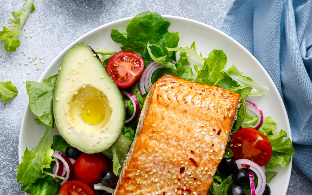 Photo of grilled salmon and avocado on a salad