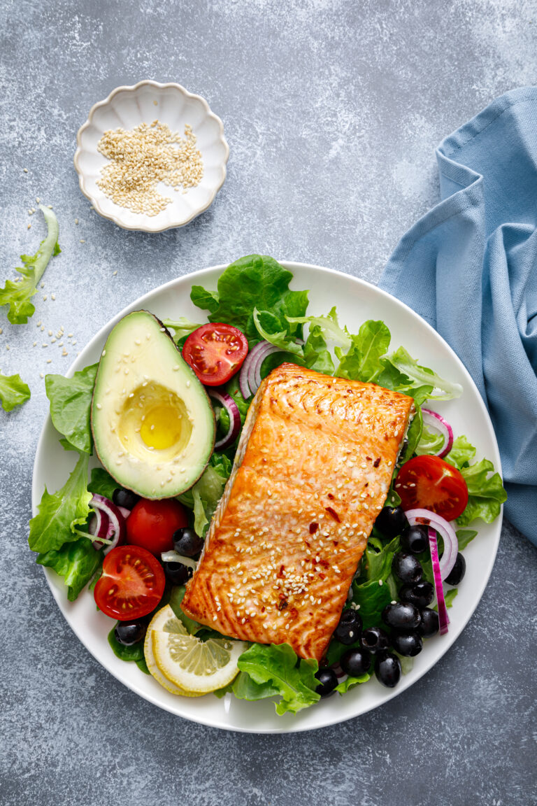 Photo of grilled salmon and avocado on a salad